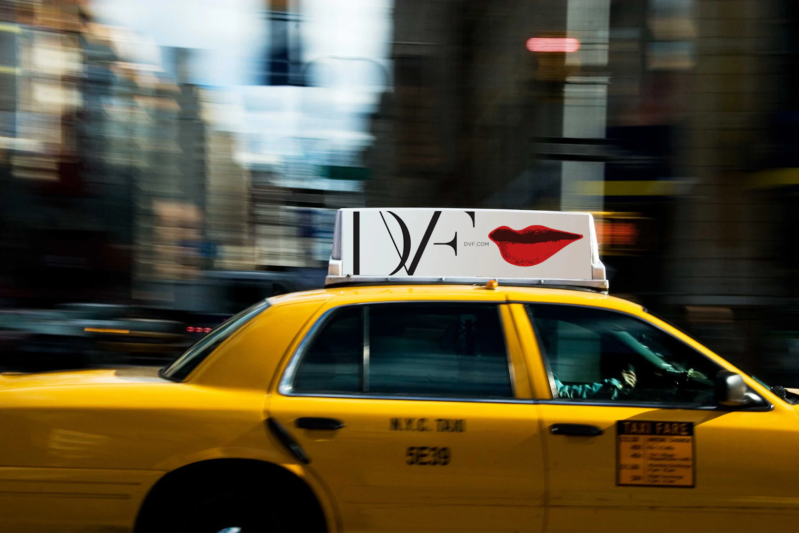 Image showing a yellow NYC taxi with a taxi top showing the DVF logo and lips.
