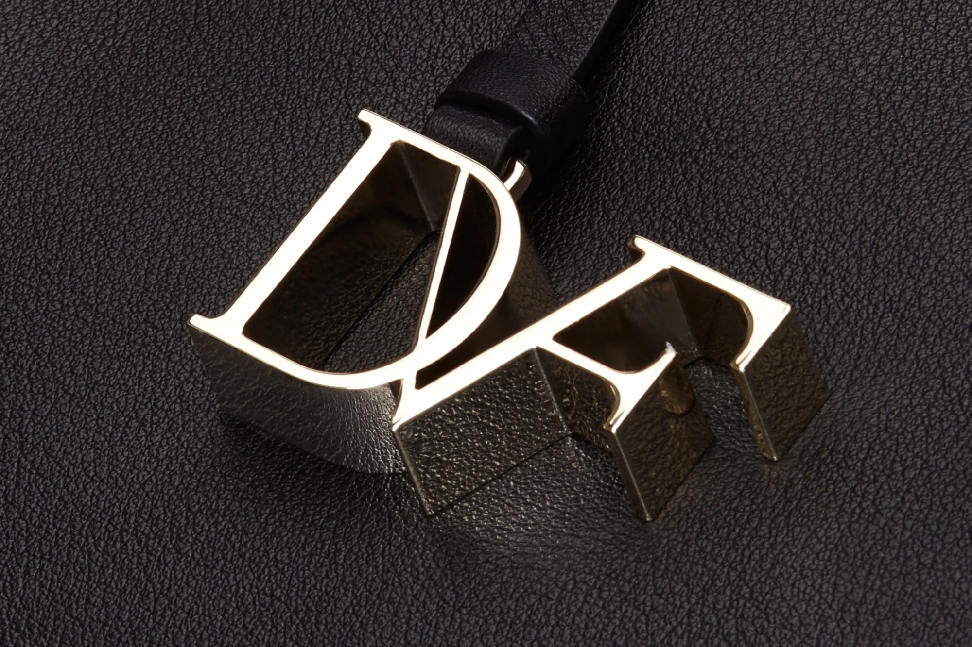 Image showing the DVF logo as hardware in gold against a black ground.