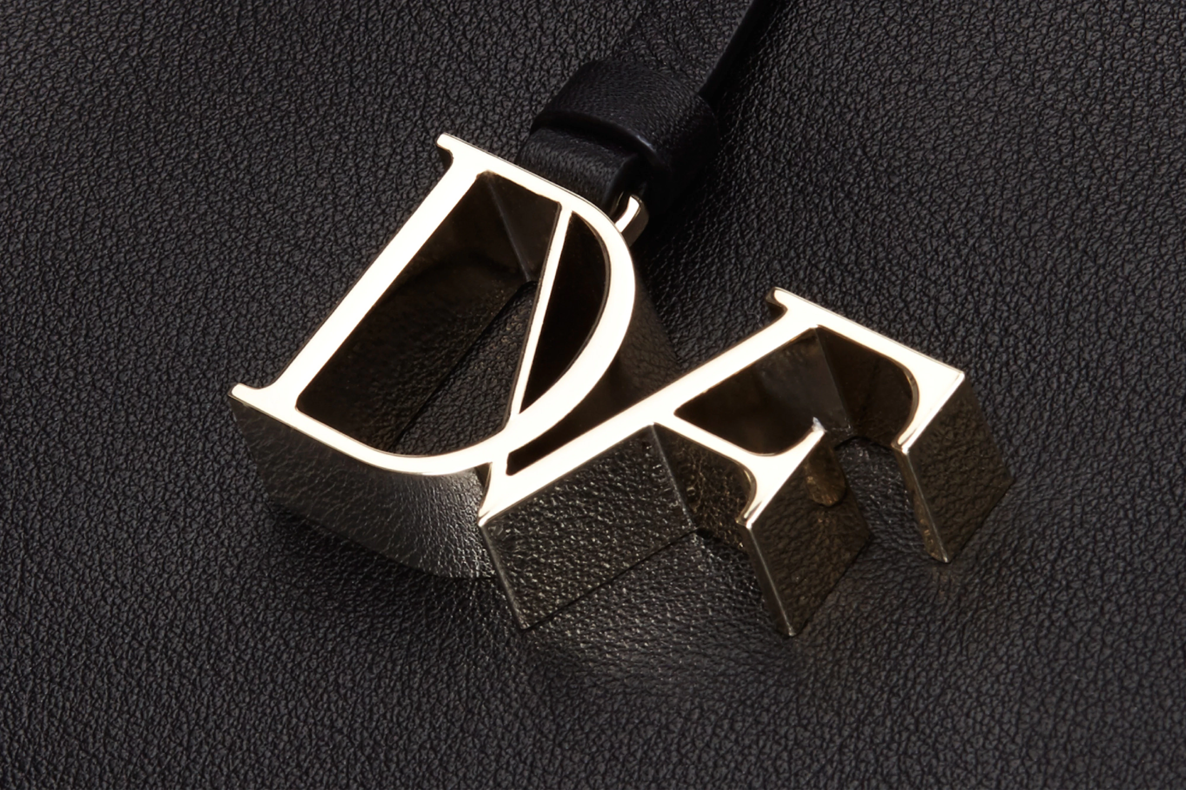 Image showing the DVF logo as hardware in gold against a black ground.