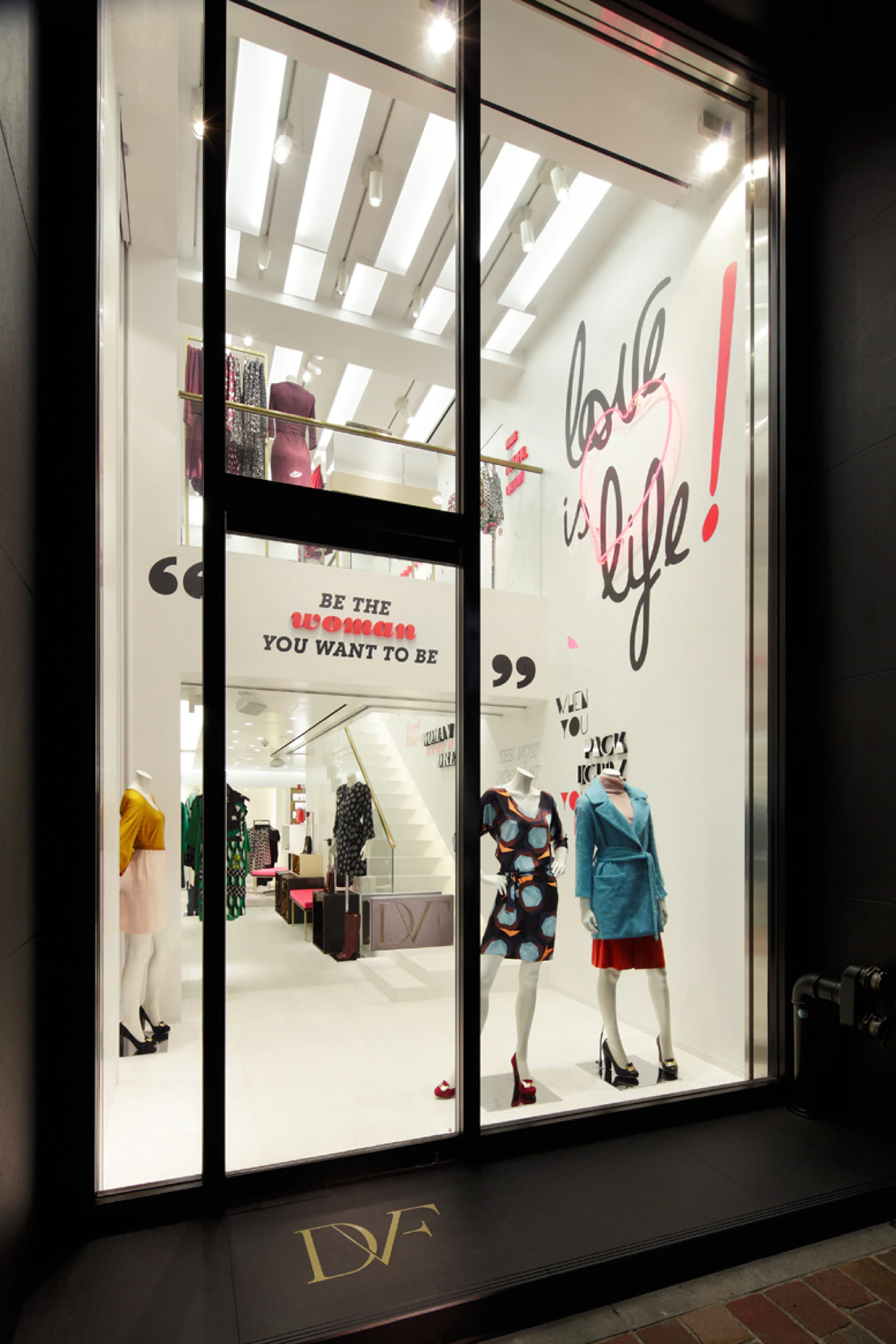 Image showing the outside of the DVF store in Tokyo. There are mannequins in the window and on the wall is an oversized LOVE IS LIFE quote.
