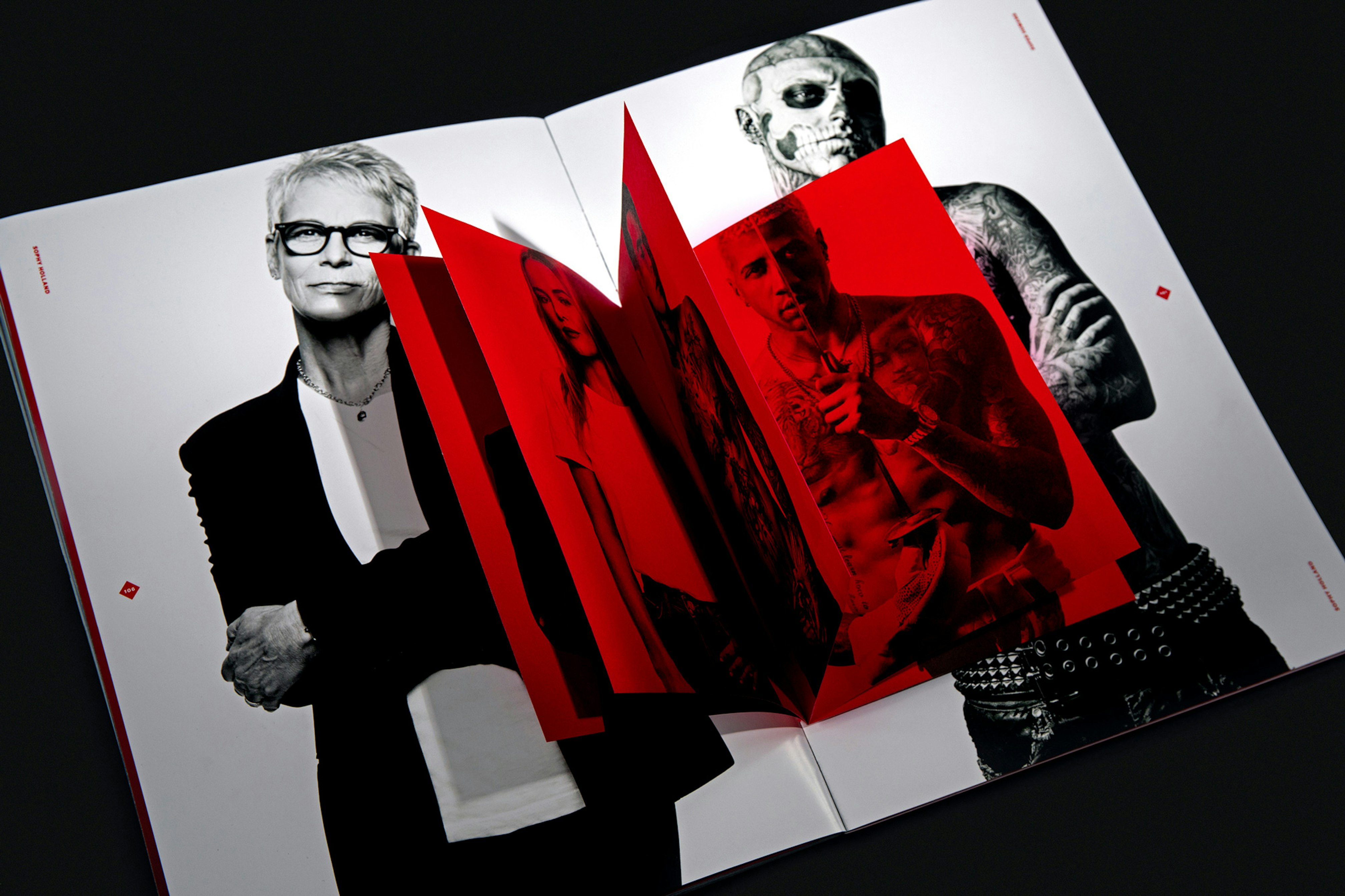 Image shows a close-up of a spread of black-and-white images with a small all-red booklet within that spread. 