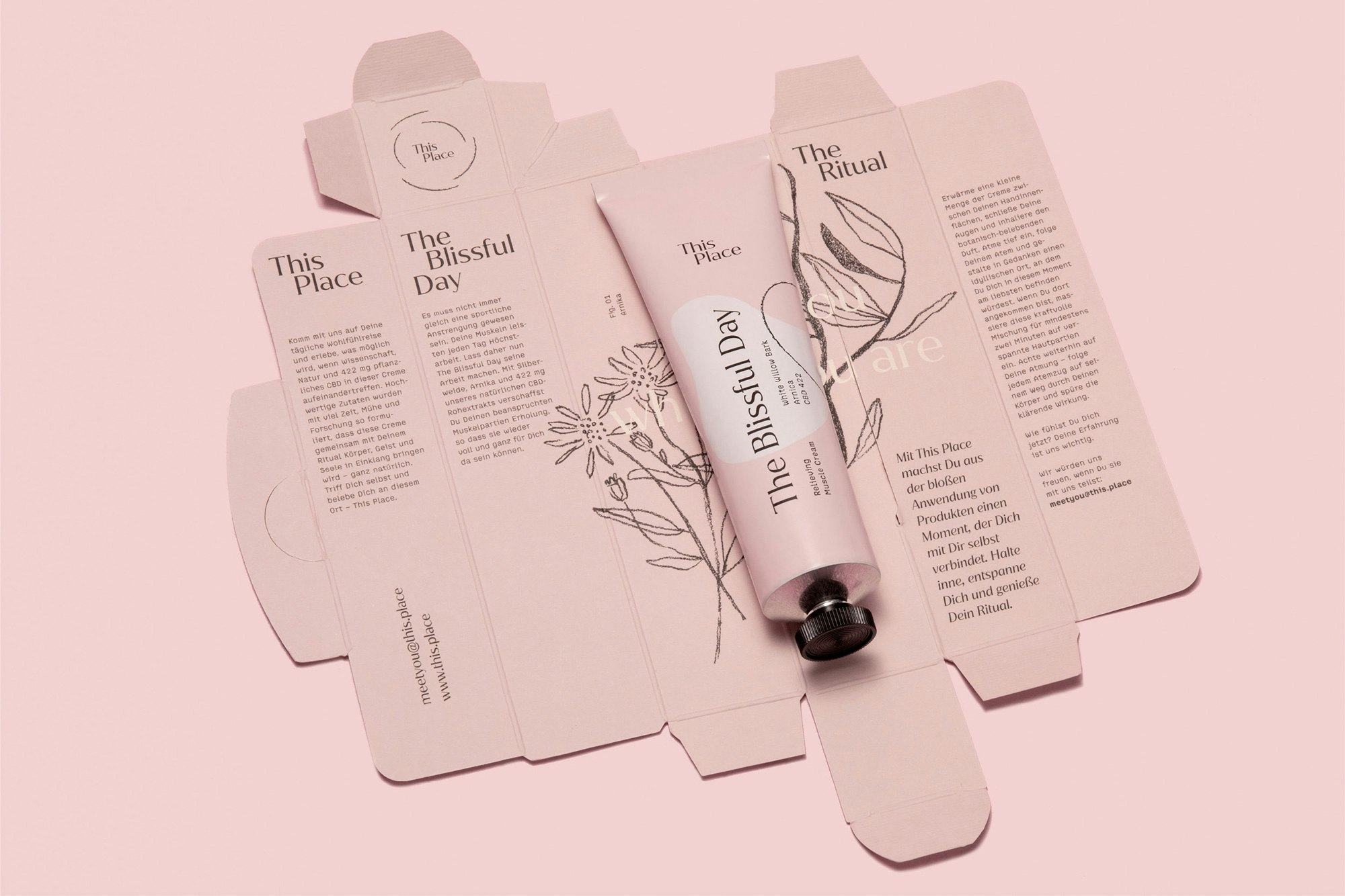 Image showing the pink tube lying on top of the open, flattened packaging.