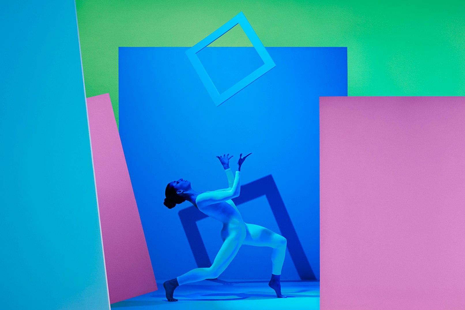 Image showing a person striking a pose while catching a white frame. The image is shades of blue, green and pink.