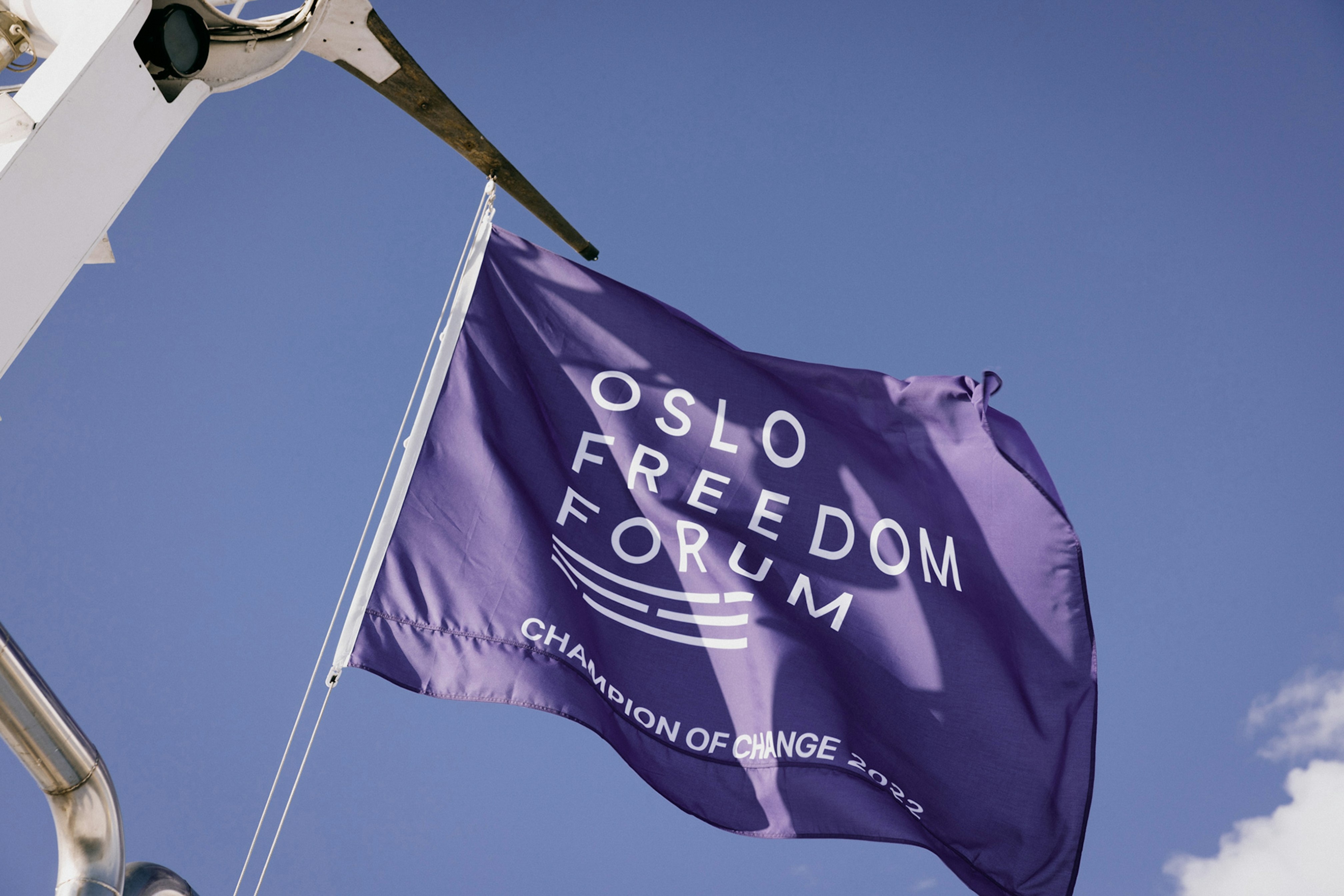 Oslo Freedom Forum logo and Champion of Change 2022 in white on a purple background.