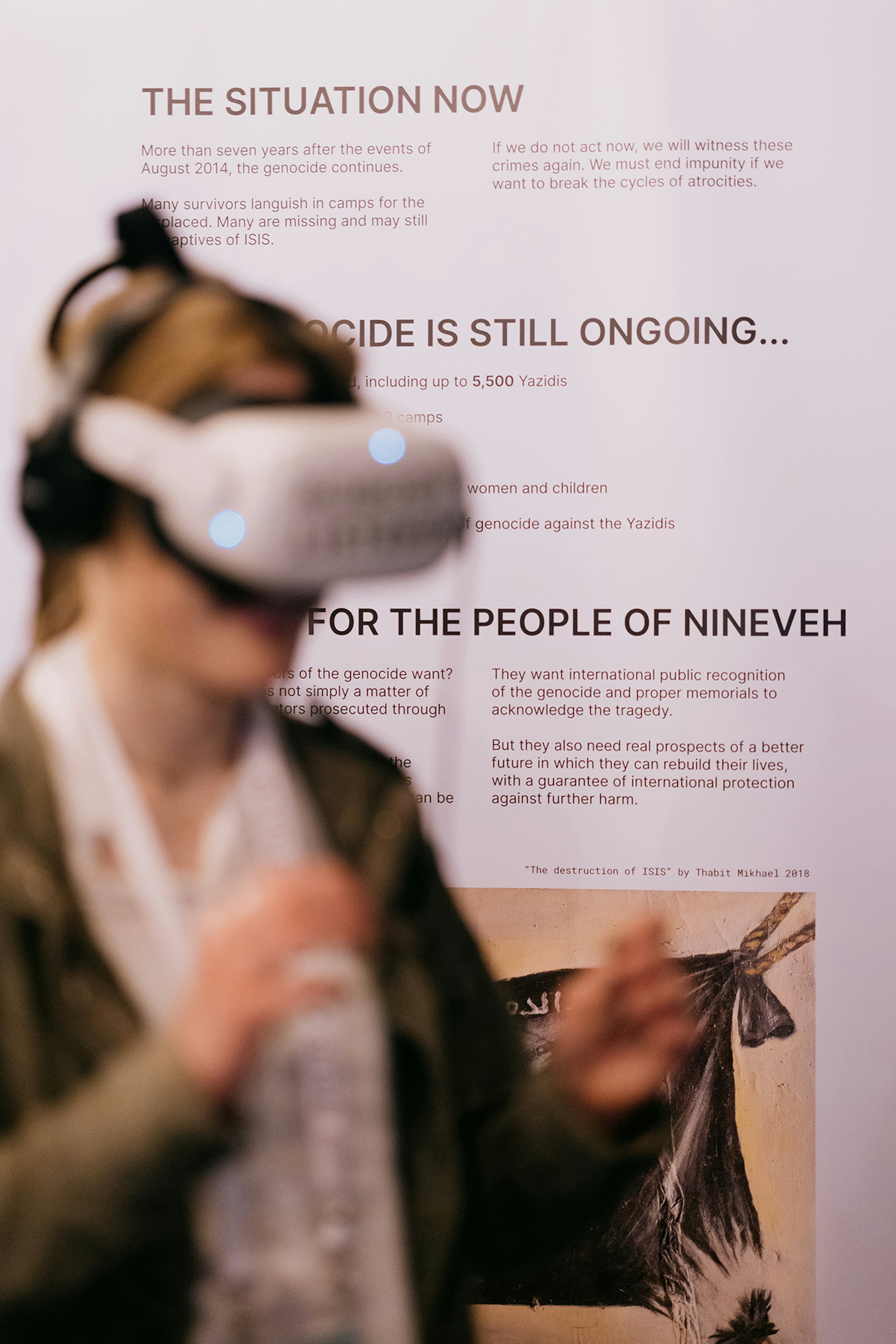 A person with a VR head set put on. In the back is a hop up with paragraphs about this expo.