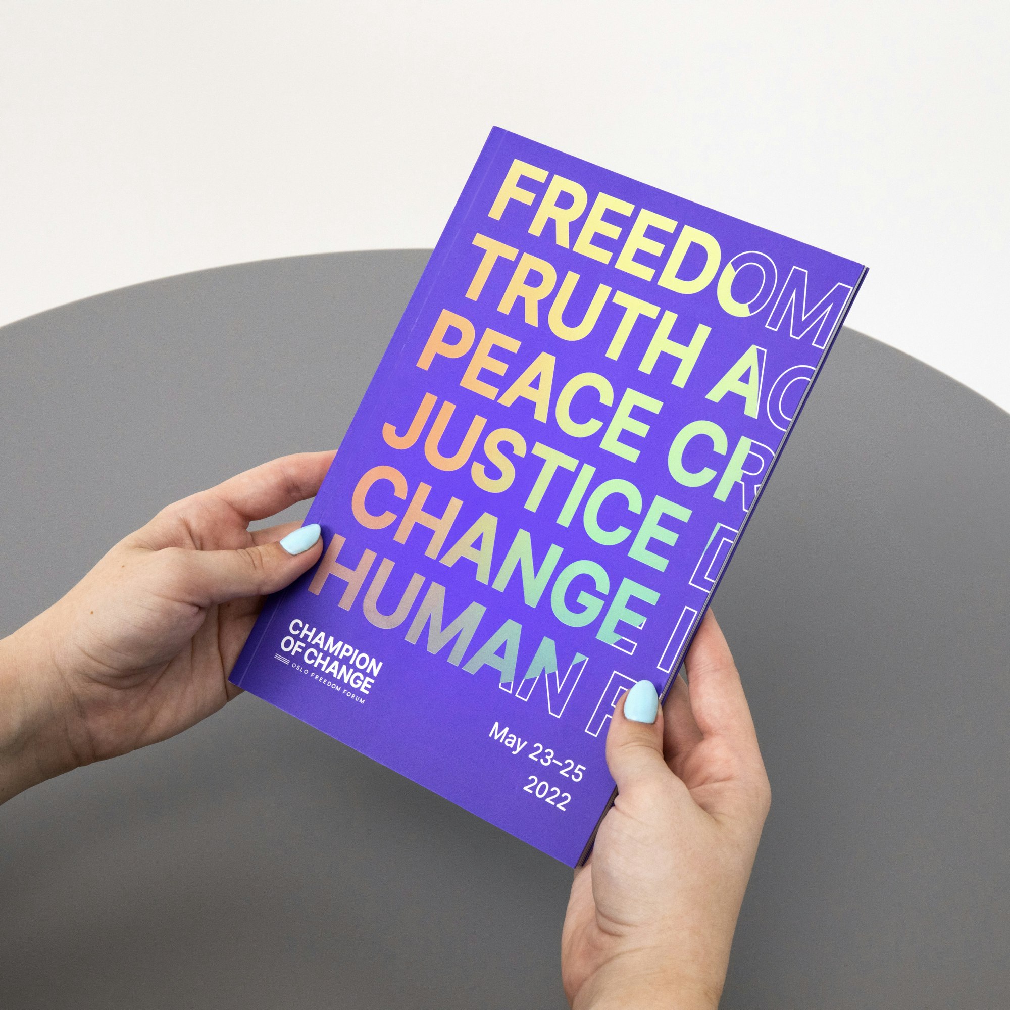 A person holding the program book in purple.