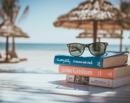 Lunette de soleil et livre posés sur une table à la plage
