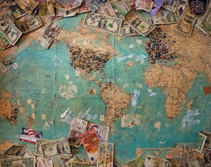 banknotes from different countries on a world map