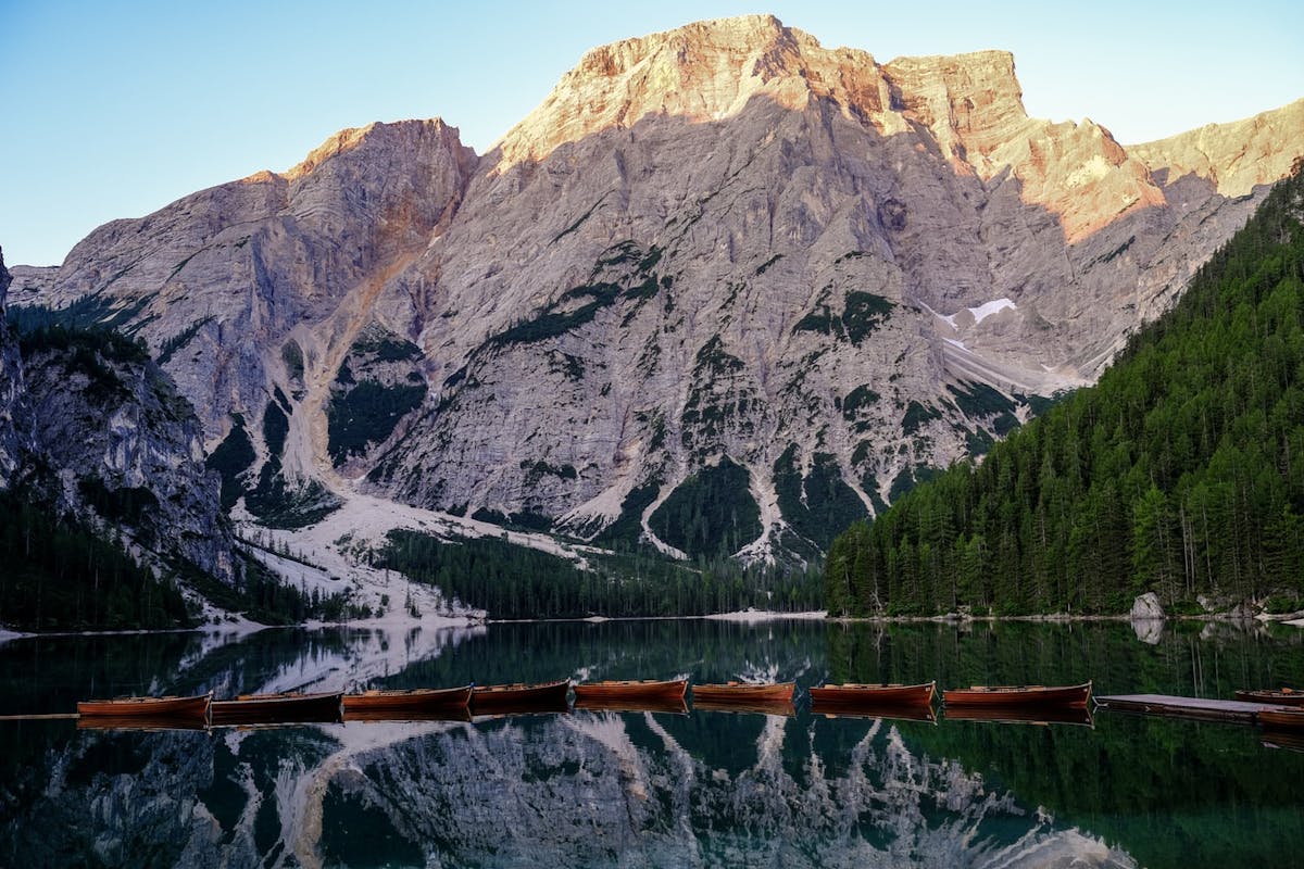 Bateaux alignés flottant sur un lac d'Italie avec des montagnes en arrière plan
