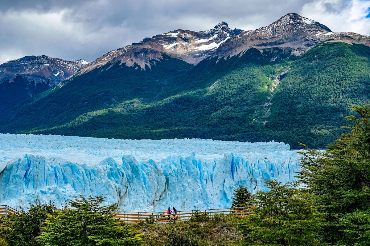 A glacier surrounded by a mountain and a forest