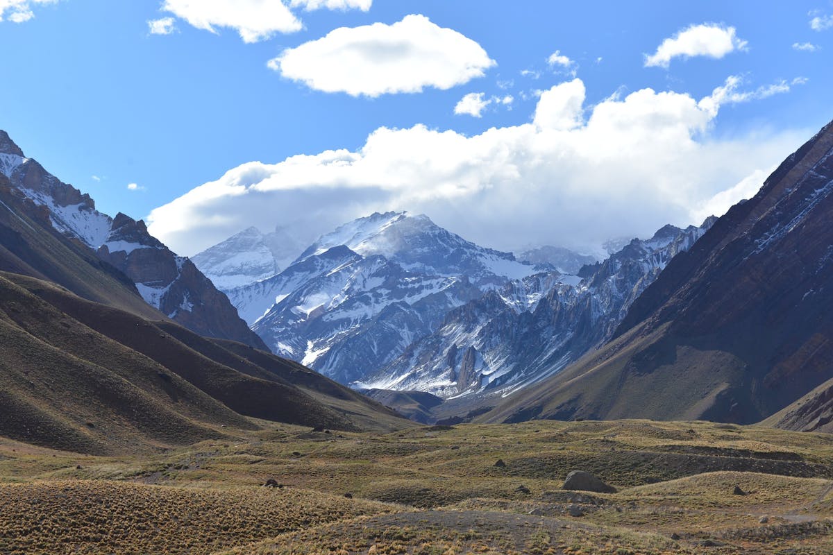 Snow-capped mountain in the background, valley in the foreground surrounded by mountains