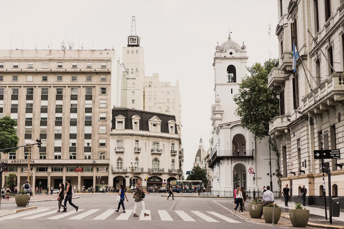 A city whose buildings are made of white stone, people crossing the pedestrian passage