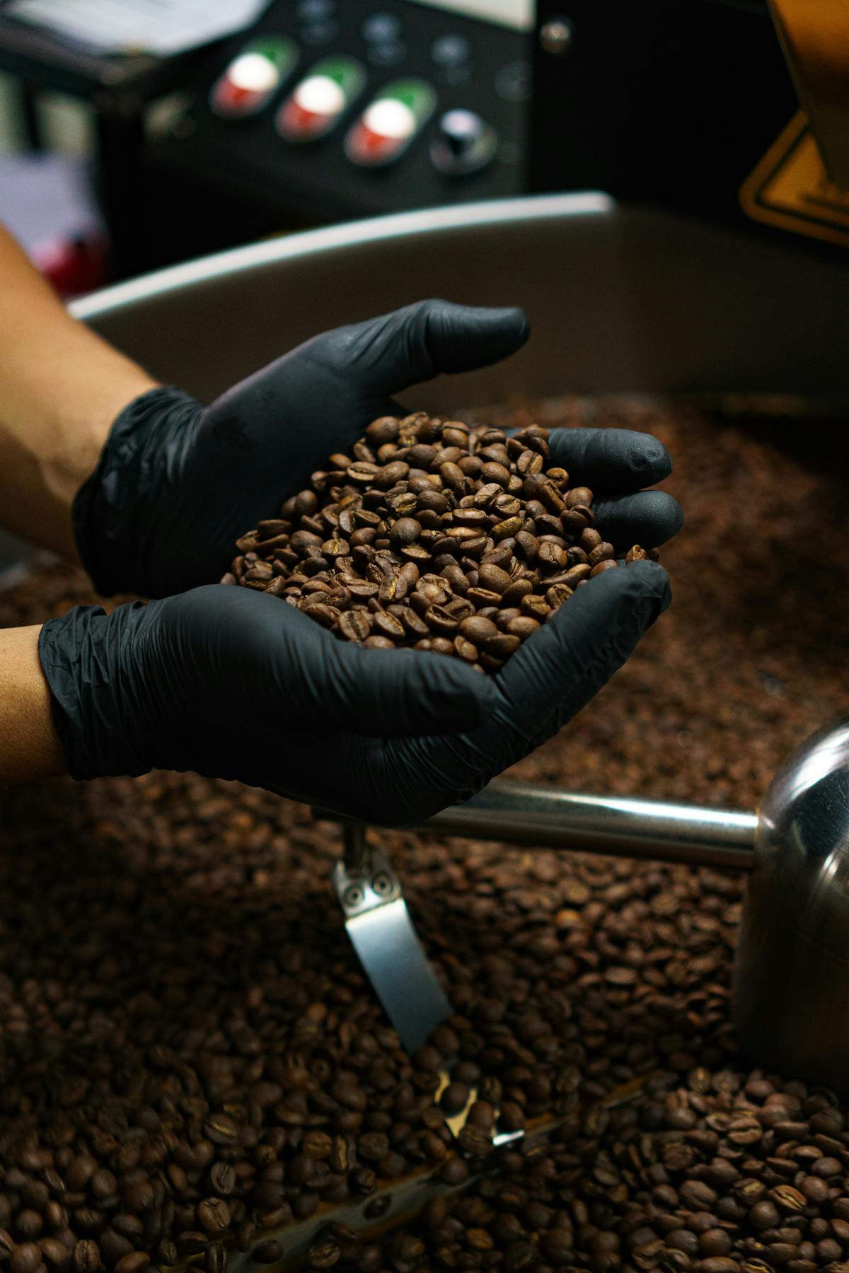 A person wearing black gloves holds coffee in his hands.