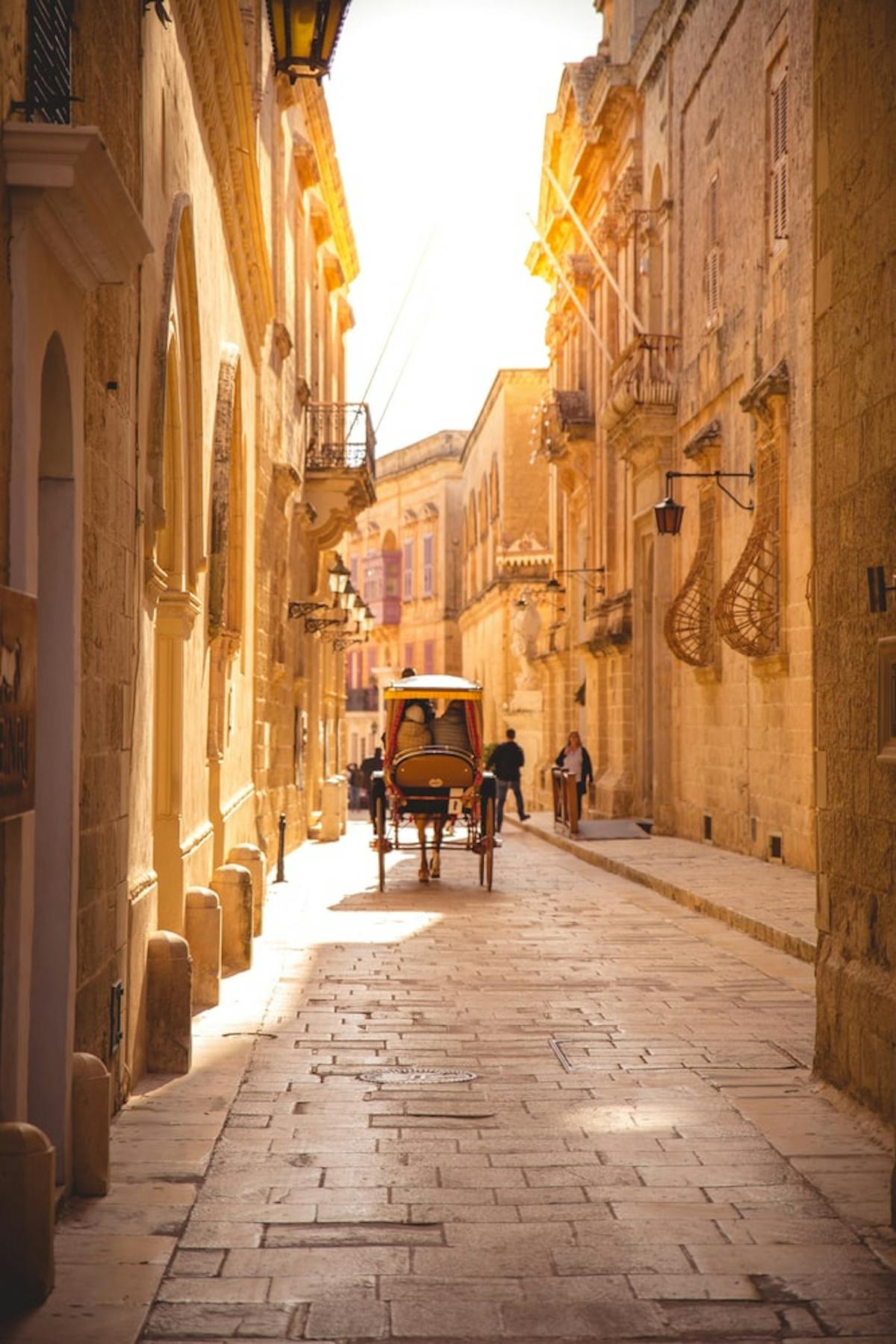 Small alley of Mdina with a horse-drawn carriage in walk