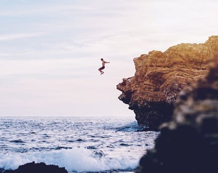 Homme qui saute d'une falaise