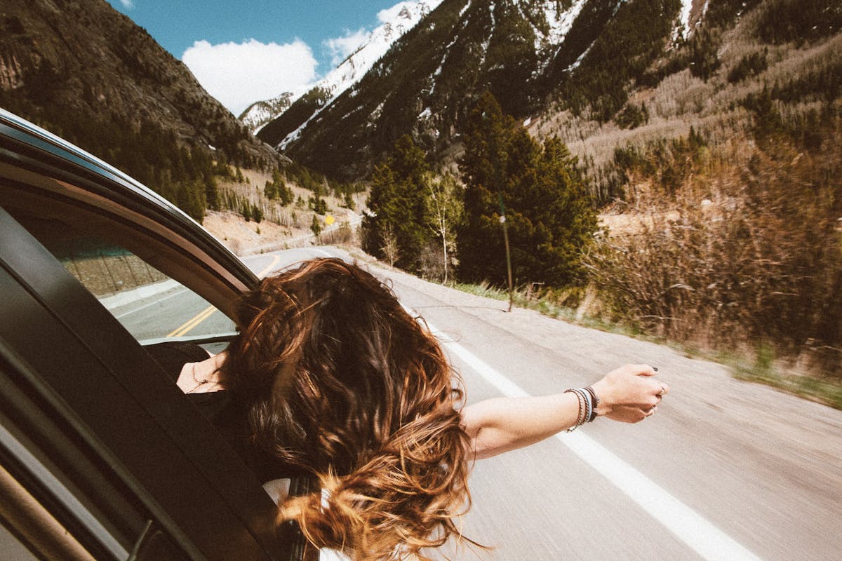 Fille en voiture dans la montagne