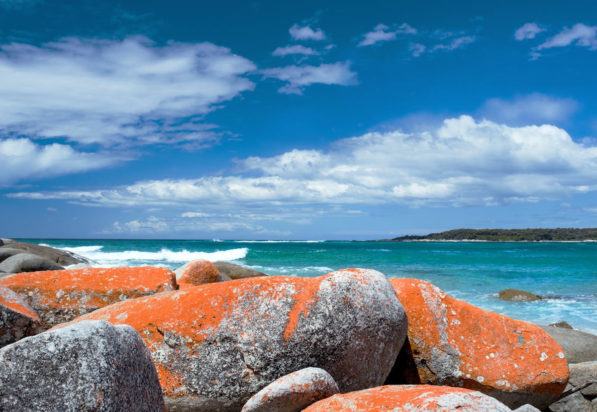 View of the glowing red rocks contrasting with the turquoise ocean.