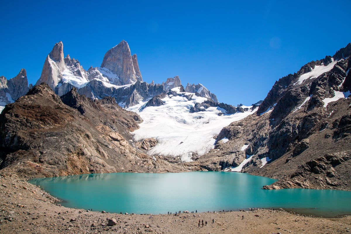 a mountain with a lake below, whose water is turquoise blue