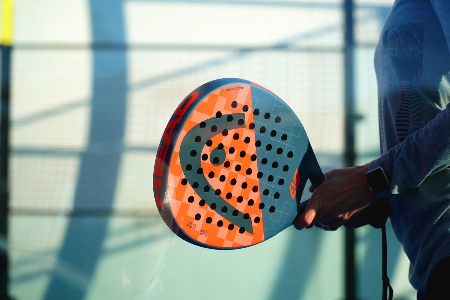 Raquette de padel orange et fond vert
