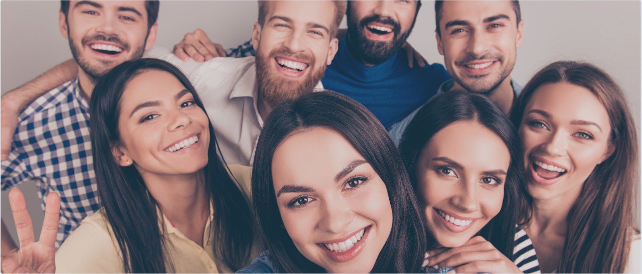 Eine Gruppe Jugendlicher schaut lächelnd in die Kamera.- Zahnzusatz-Experten Ihr Experte für eine vertrauenswürdige Zahnzusatzversicherung