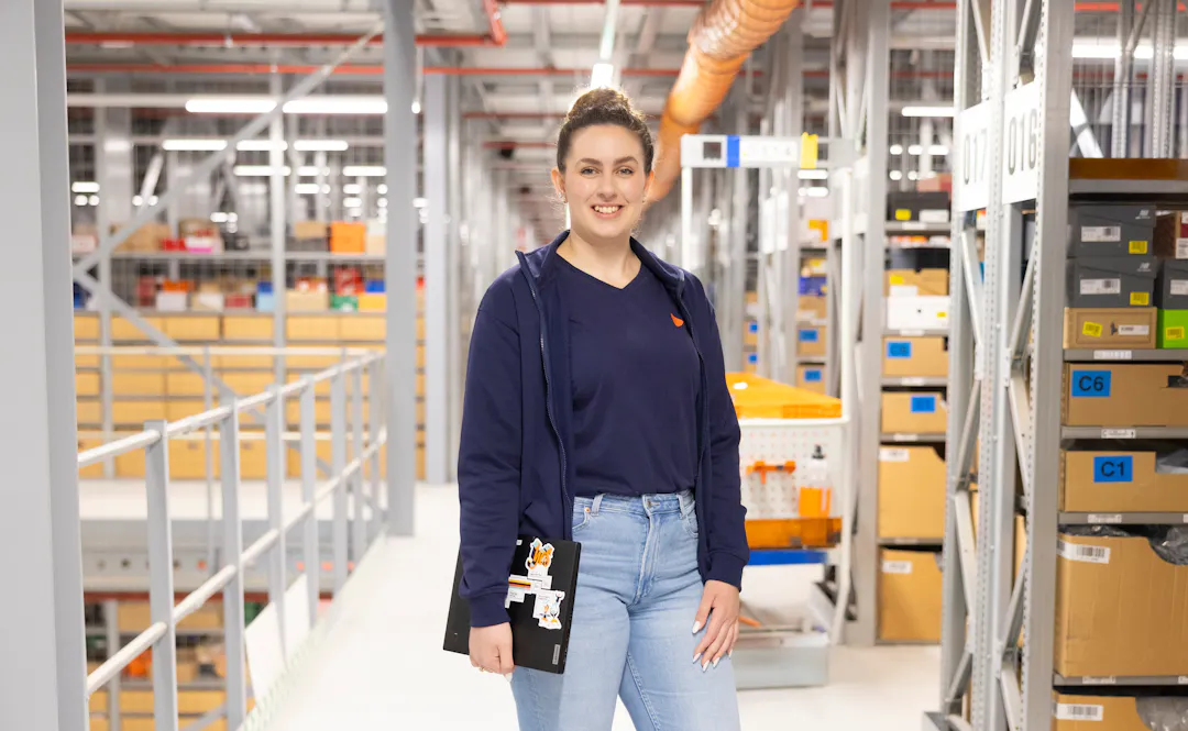 A department lead at Zalando Logistics in front of the aisles in the warehouse.