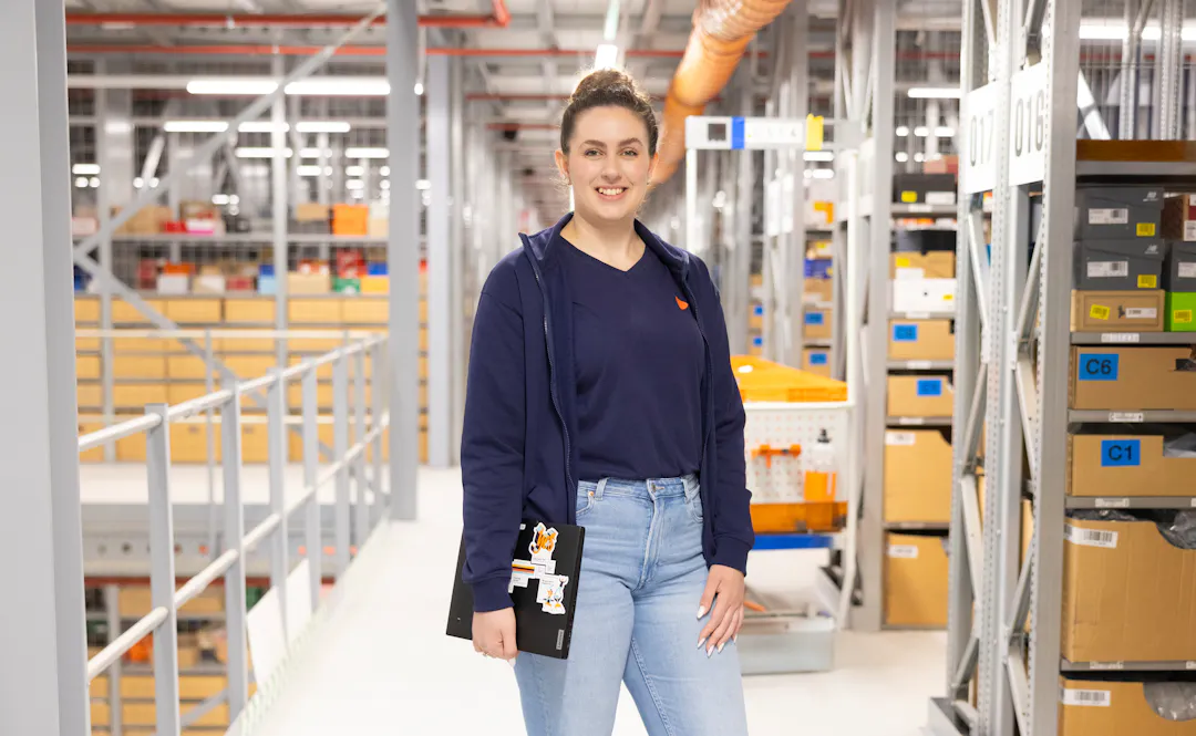 A department lead at Zalando Logistics in front of the aisles in the warehouse.