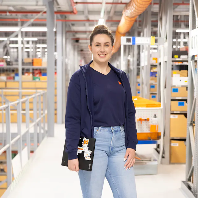A department lead at Zalando Logistics in front of the aisles in the warehouse.