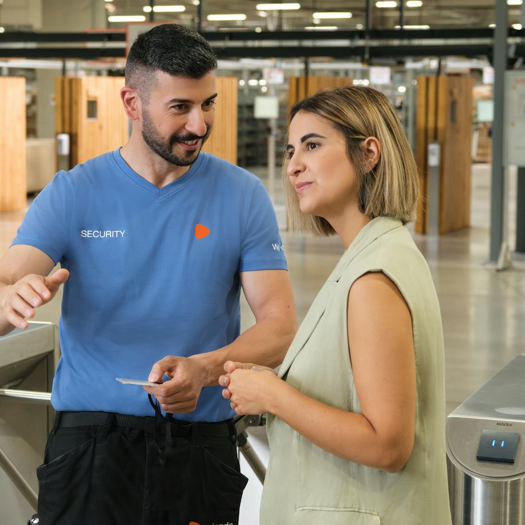 Two people having a discussion in front of the electric security gate at the warehouse