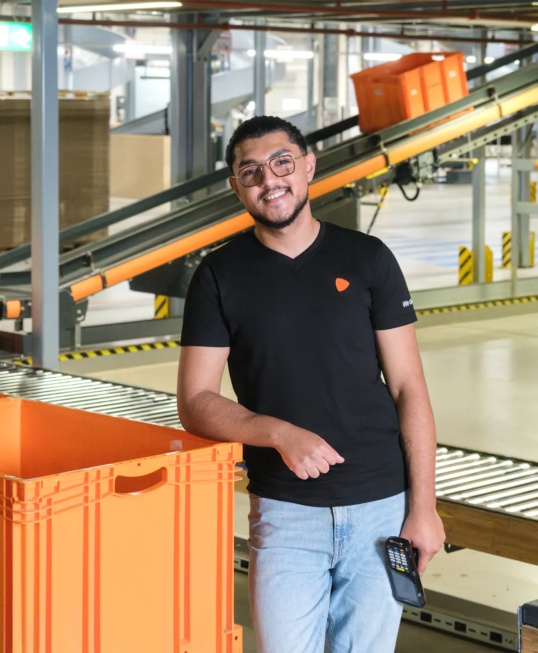 A person standing next to an orange container at a warehouse