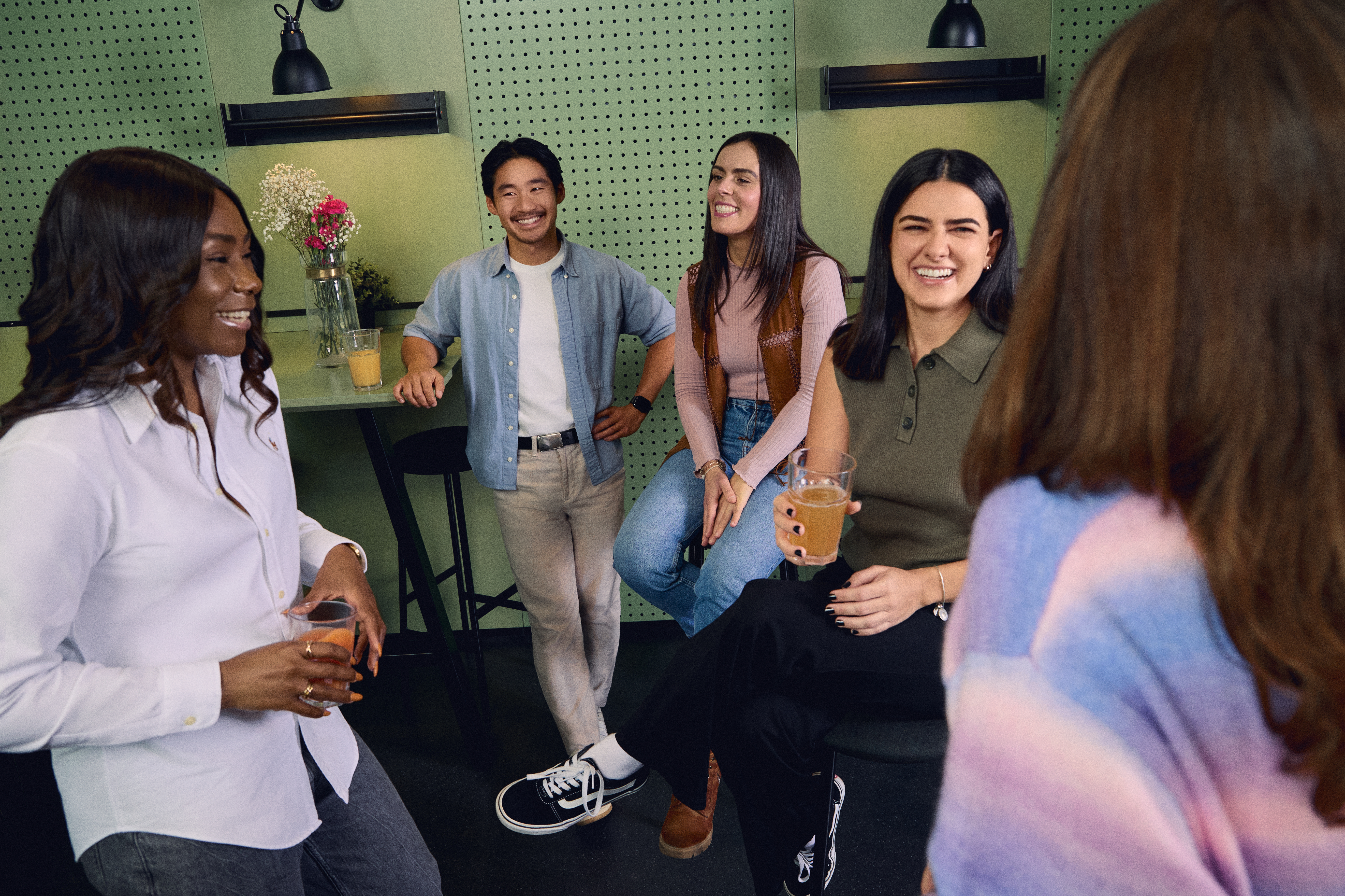 A high-resolution photo showing Zalando employees engaged in a networking session, enjoying snacks and discussing career growth in an inclusive, high-energy environment.