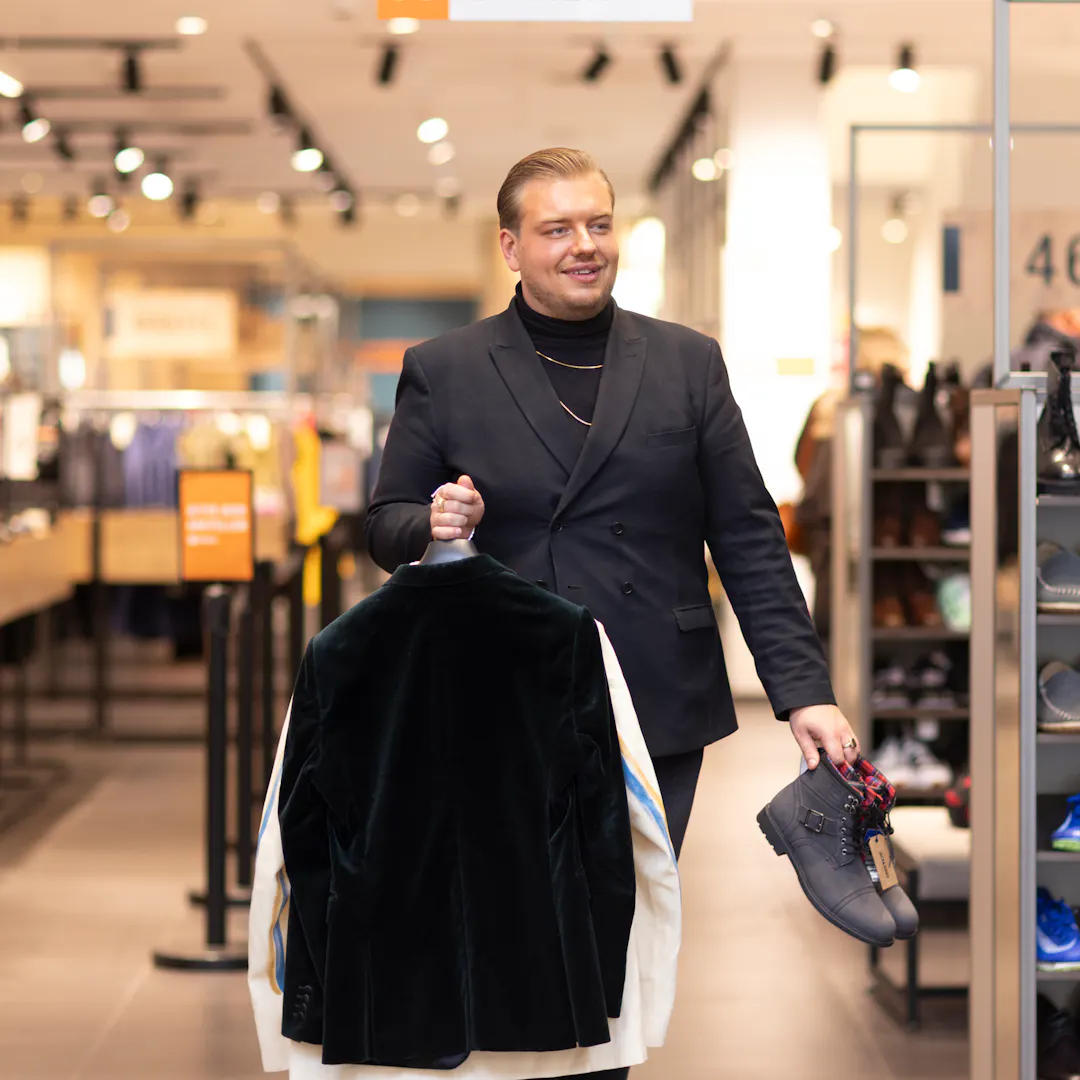 Outlet by Zalando colleague is working on the floor, organising clothes and shoes.