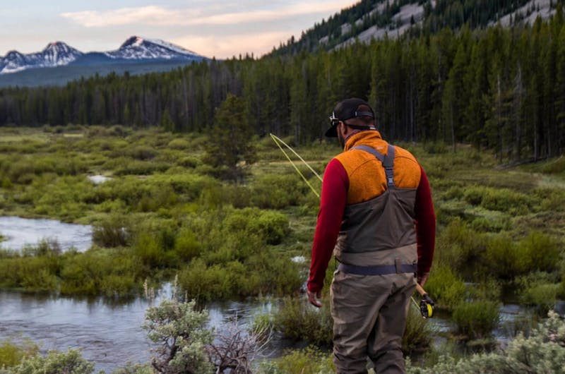 Man walking outdoors with fly fishing gear