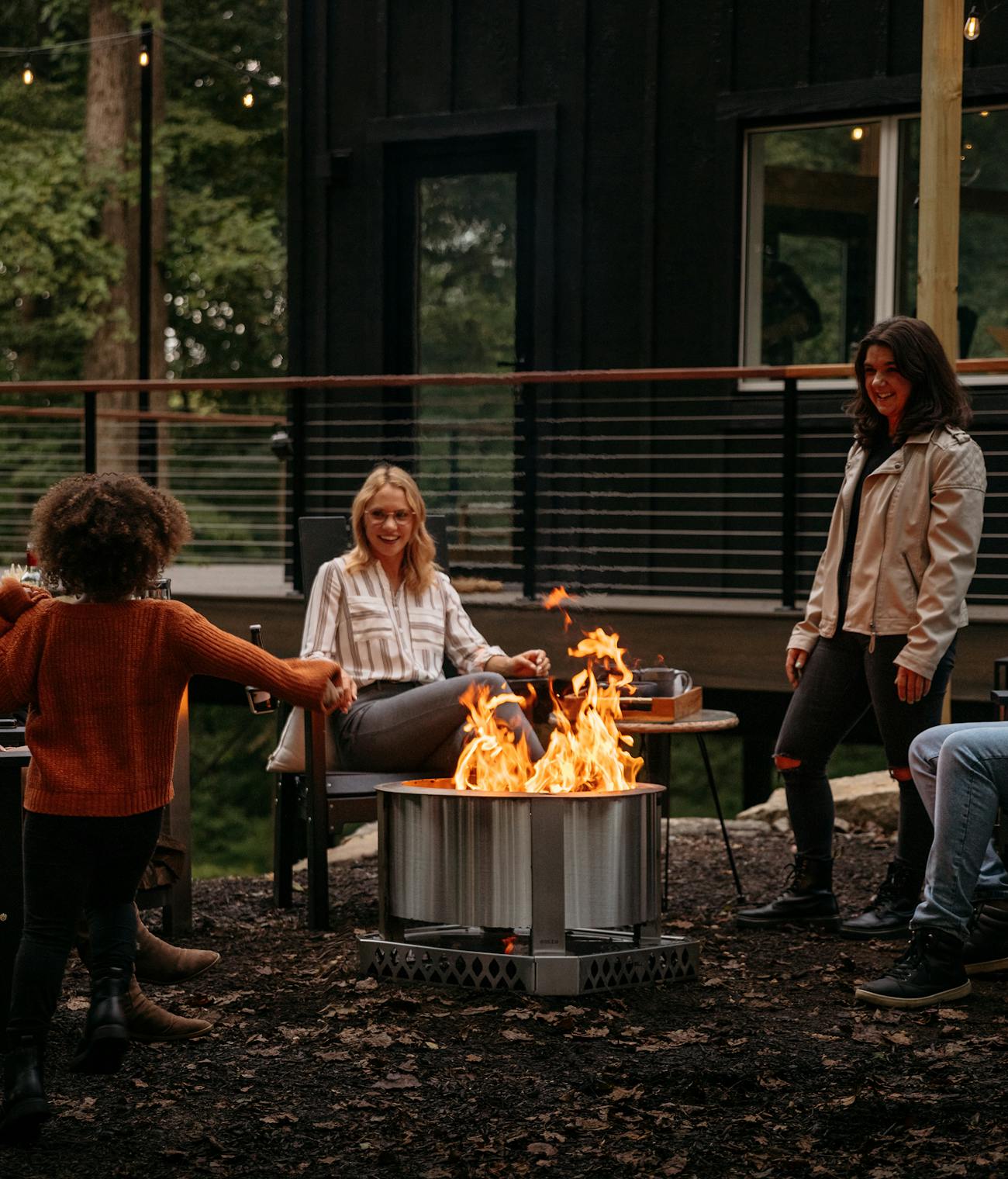 A group of friends hanging out around a Breeo fire pit