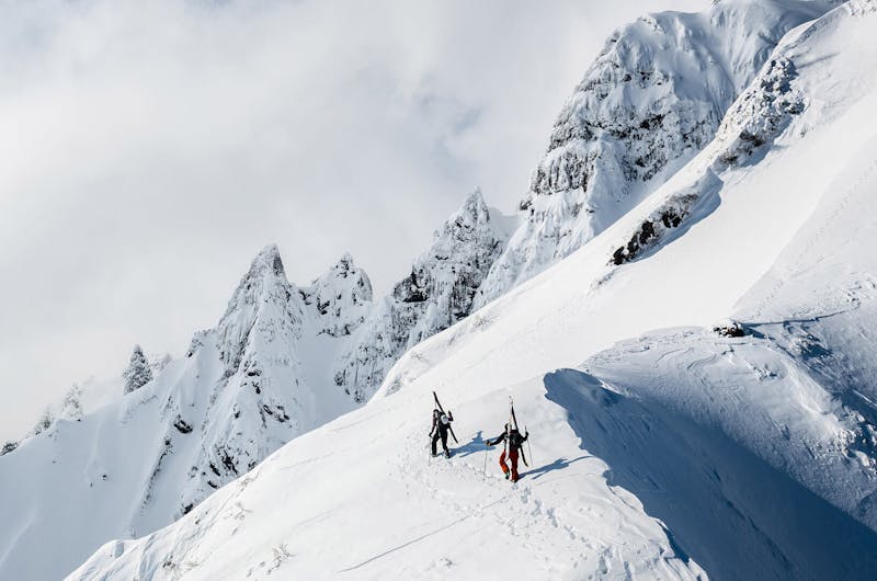 Two people hiking in snowy mountains using Black Diamond Equipment