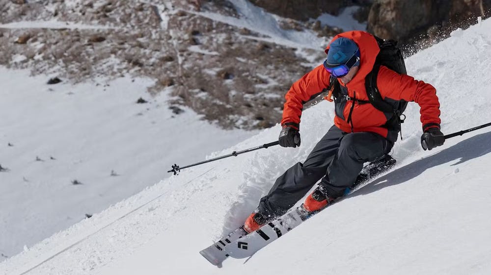 Person in red snow coat skiing down a mountain