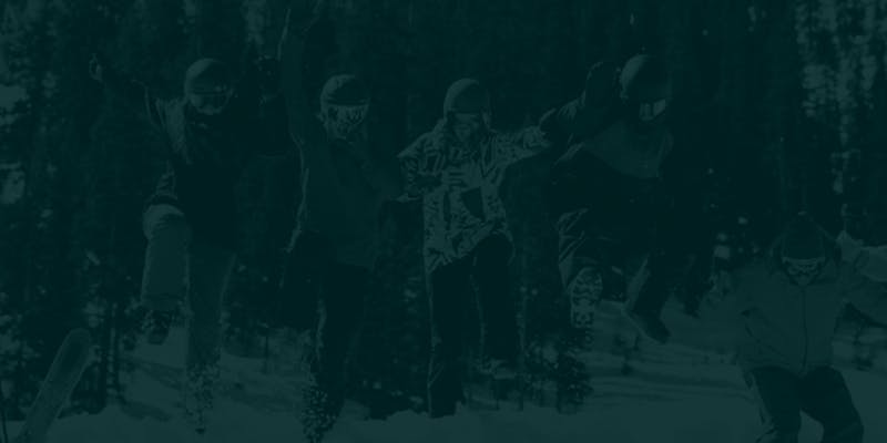 Several people in snow gear jumping into snow with dark overlay