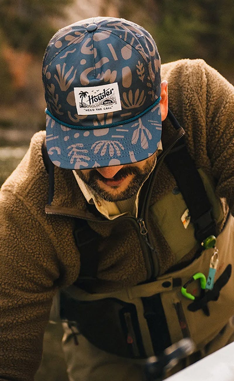 A man fishing, wearing Howler Brothers clothing