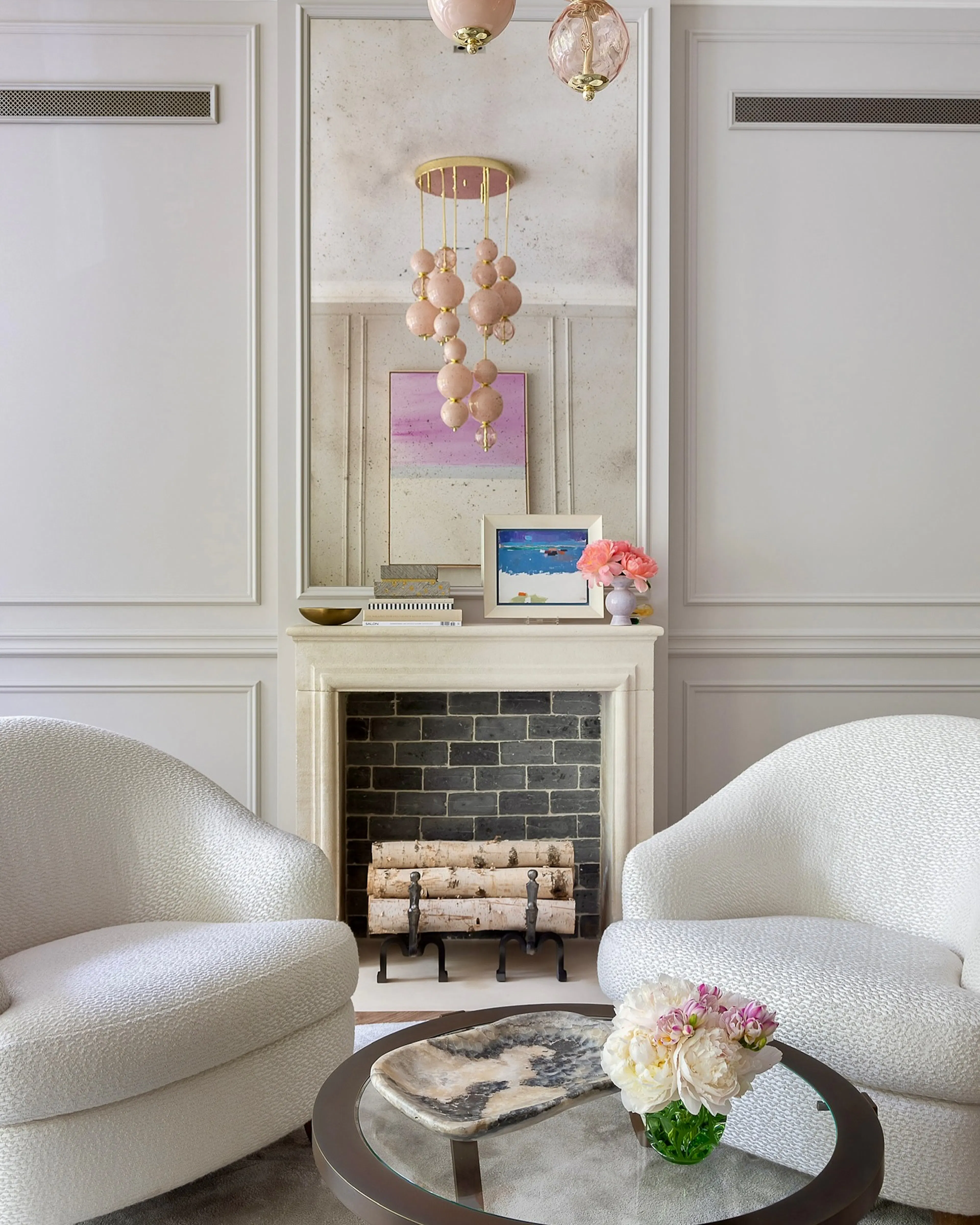 Salon mit Kamin und weißen Bouclé-Sesseln