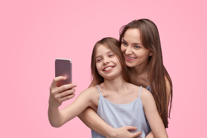 Mãe e filha mexendo no celular