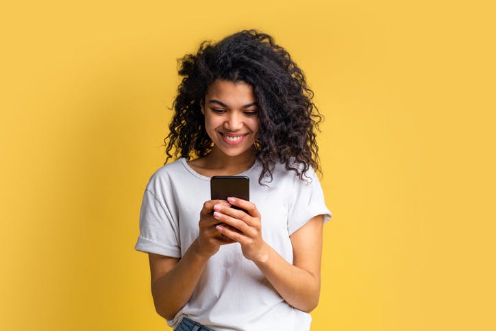 Menina sorrindo e mexendo no celular