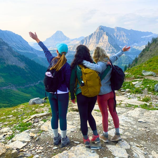 3 friends hiking with mountain backdrop 
