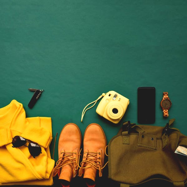 Mens clothes, camera,Swiss army knife, phone, watch and bag on dark green background
