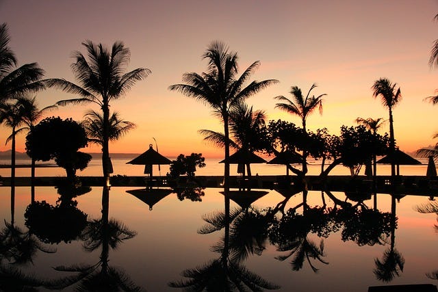 Bali, Pool, Beach and Palm Trees at Sunset
