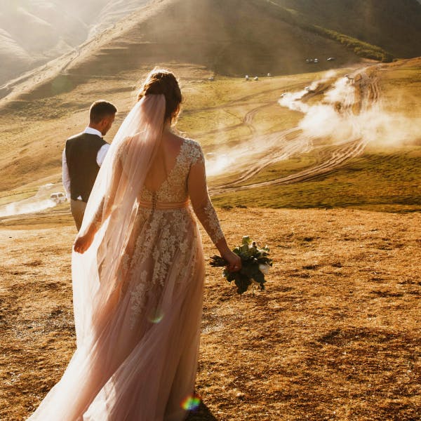 Couple in wedding clothes on a mountain trail for destination weddings 