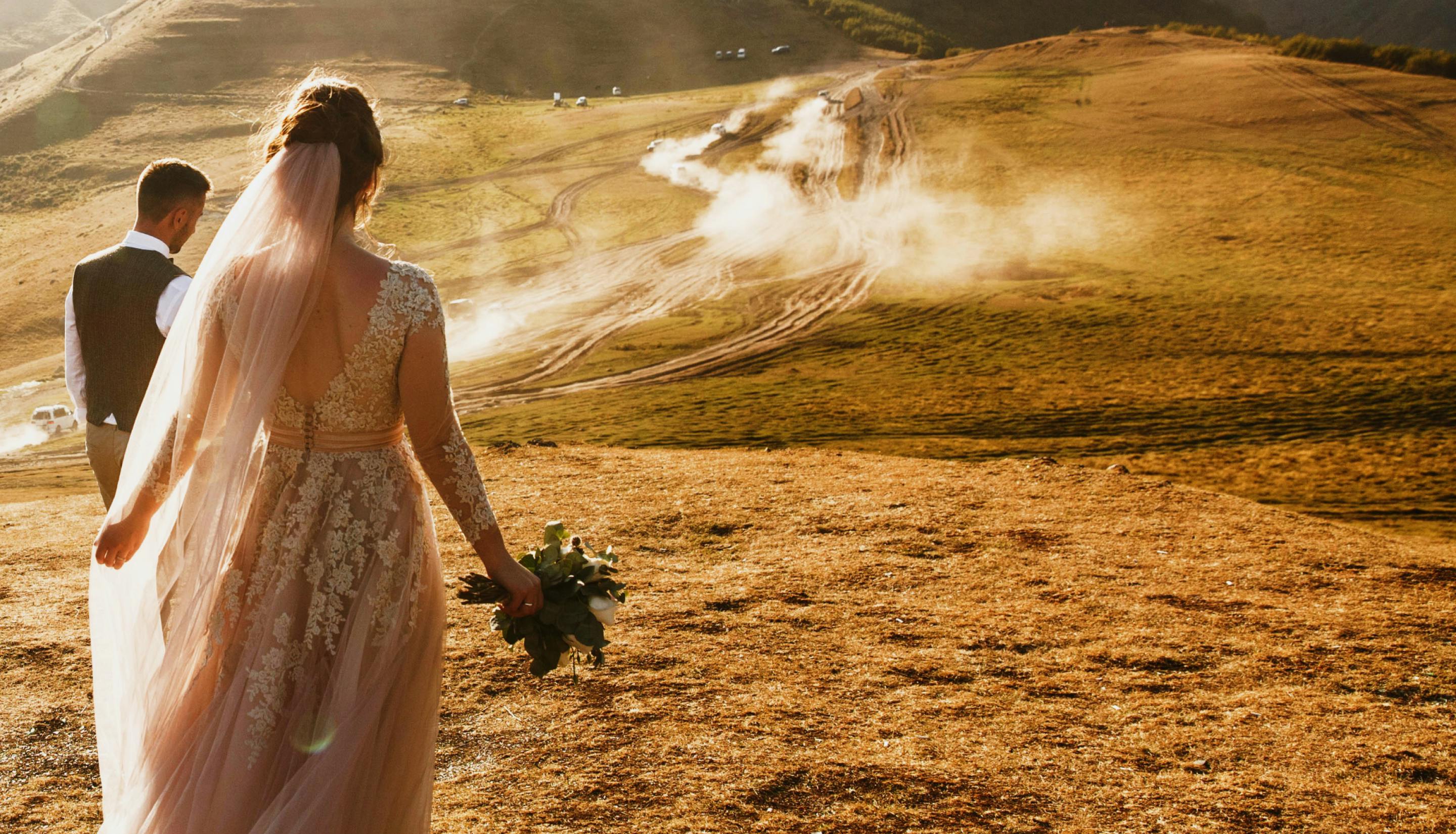 Couple in wedding clothes on a mountain trail for destination weddings