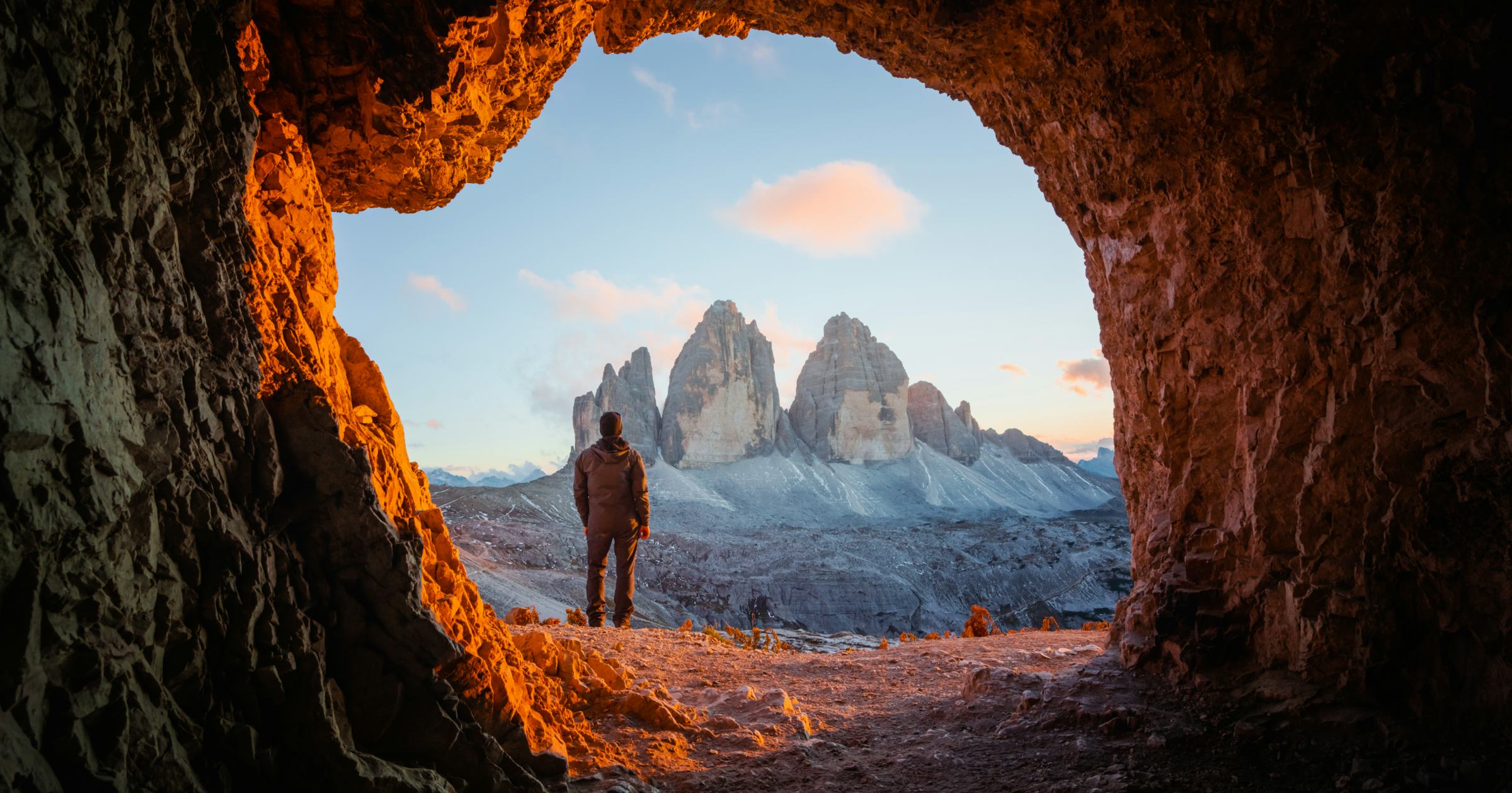 Tre Cime Di Lavaredo peaks in incredible orange sunset light. View from the cave in the mountain against Three peaks of Lavaredo, Dolomite Alps, Italy, Europe