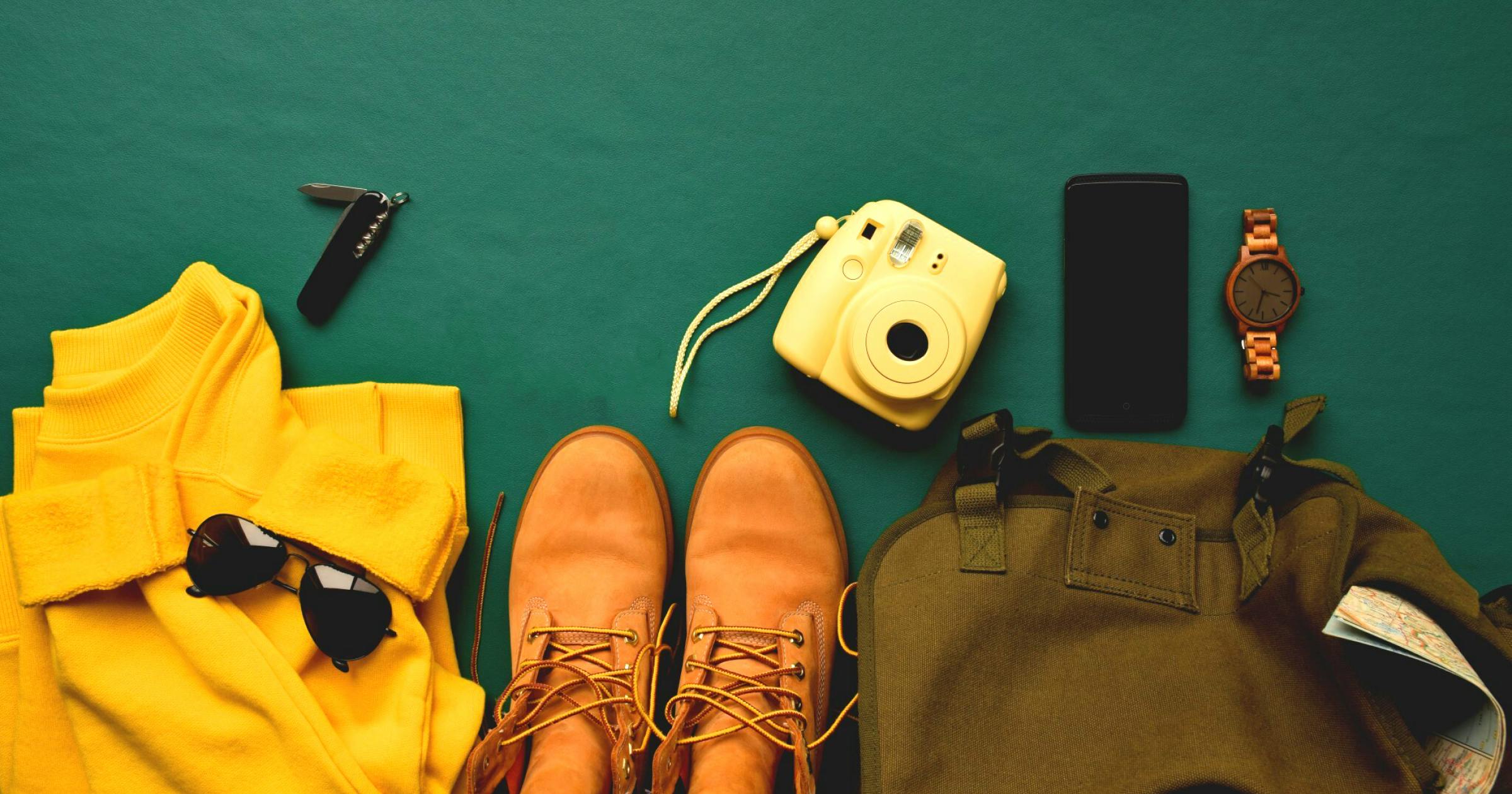 Mens clothes, camera,Swiss army knife, phone, watch and bag on dark green background