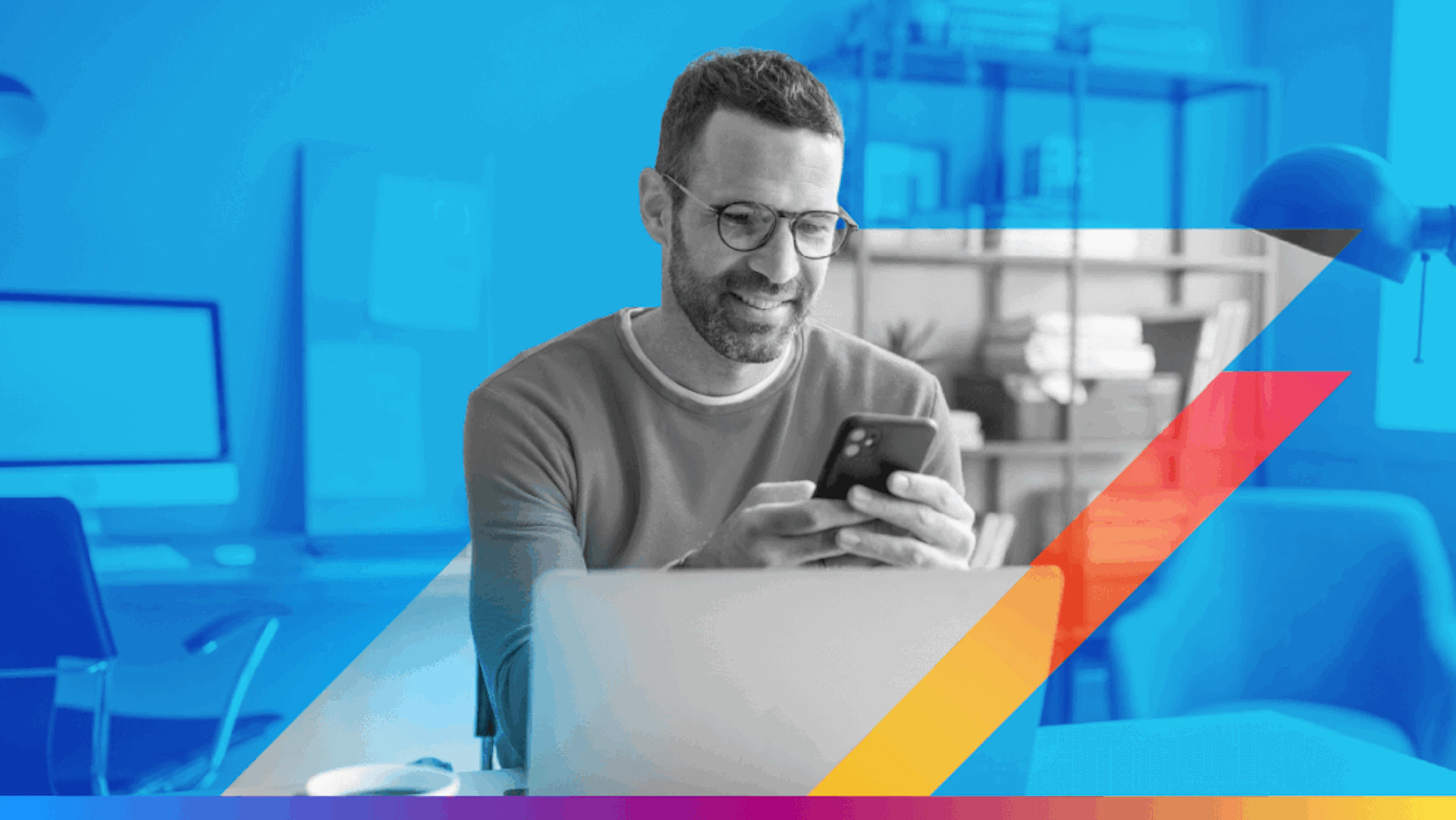 a person looking at a phone in front of a laptop - featured image for new gmail alias feature article