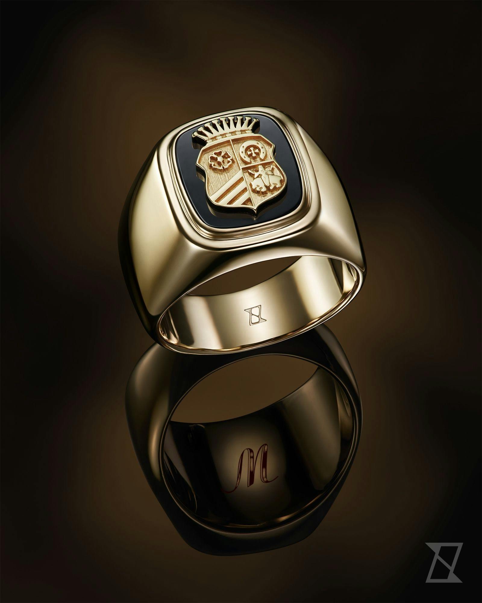Sygnet na zamówienie z herbem rodowym i gładkimi bokami skrywa inicjał wygrawerowany wewnątrz pierścienia.