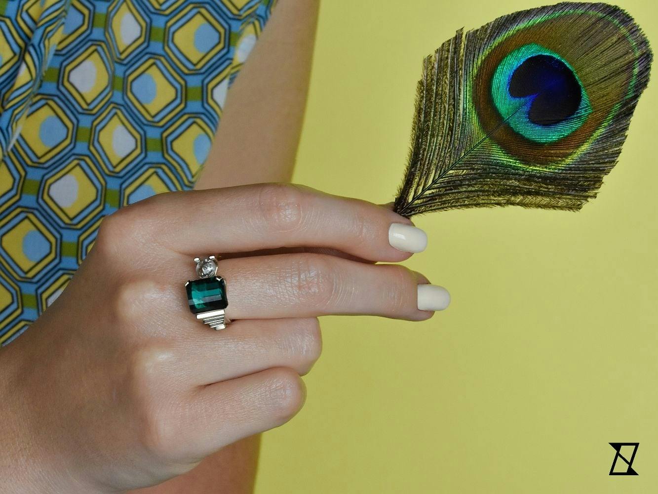 A ring with Indigo Tourmaline on a finger. 